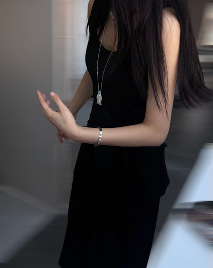 小丞飾魚骨造型長項鍊，採用半透明晶石與亮藍色珠飾設計，模特兒身穿黑色連身裙佩戴展示