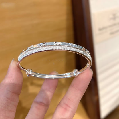 小丞飾銀色雙層手環，結合磨砂質感與精緻星芒刻紋，伸縮調節設計展現優雅知性美。