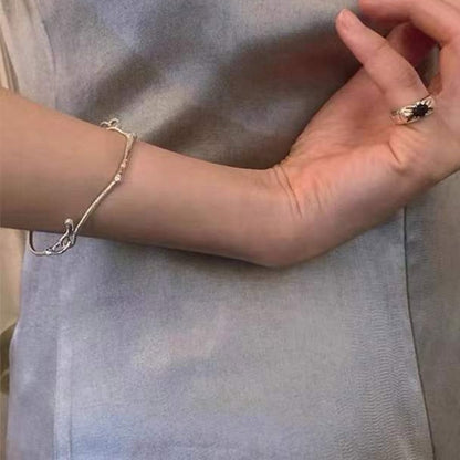 小丞飾質感簡約樹枝造型手環，銀色金屬材質呈現自然有機紋理，佩戴於手腕展現優雅藝術氣息。
