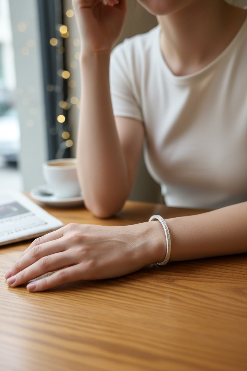 小丞飾質感手工鍛造紋理手環，銀色錘紋設計簡約優雅，佩戴於模特兒手腕上，展現低調奢華的日常穿搭風格。