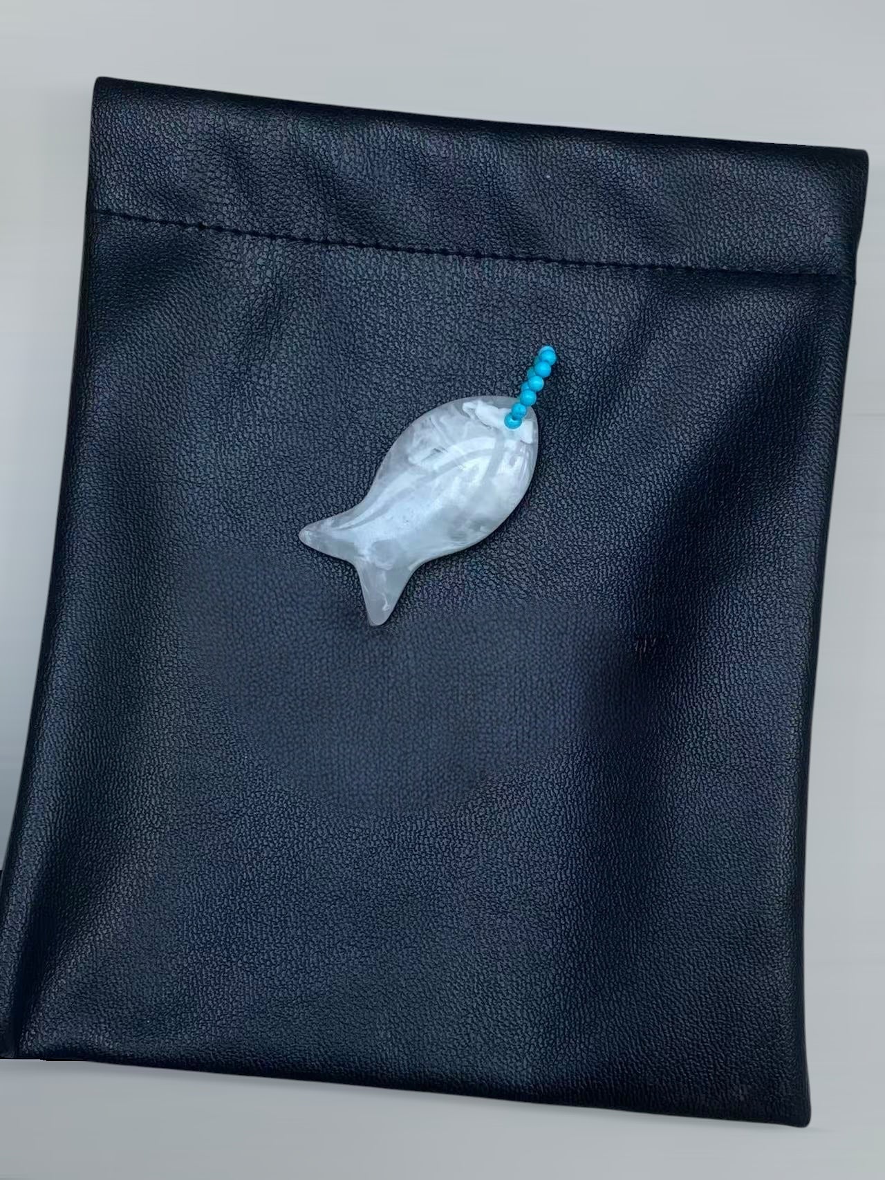 小丞飾魚骨造型長項鍊，採用半透明晶石雕刻魚身，搭配亮藍色珠飾，呈現海洋風格的精緻飾品。